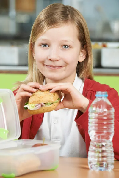 Chica sentada en la mesa en la cafetería de la escuela comiendo sano lleno — Foto de Stock