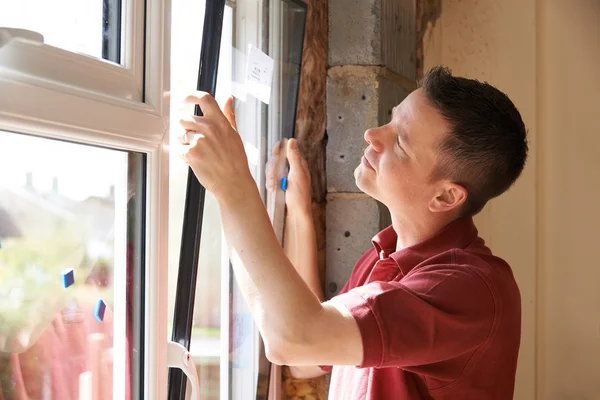 Bauarbeiter installiert neue Fenster im Haus — Stockfoto