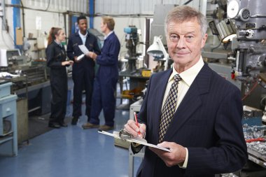 arka planda personeli ile mühendislik fabrika sahibi