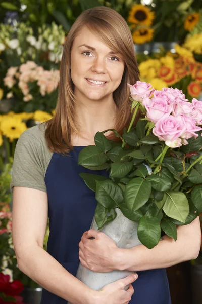 Retrato de Florista en la tienda sosteniendo cubo de rosas — Foto de Stock