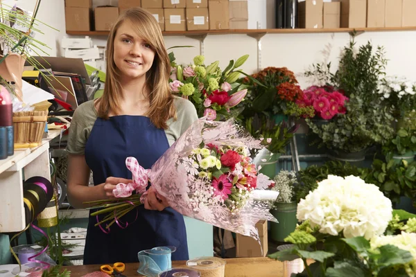 Floristería trabajando en ramo en la tienda — Foto de Stock