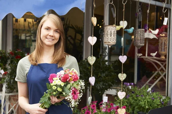 Florist Standing Outside Shop with Bunch of Flowers — стоковое фото