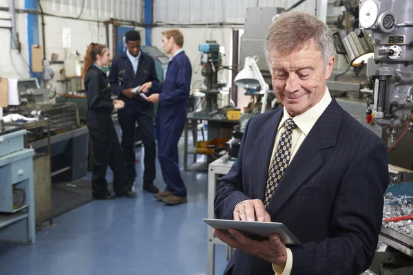 Inhaber der Maschinenfabrik mit digitalem Tablet und Mitarbeitern in — Stockfoto