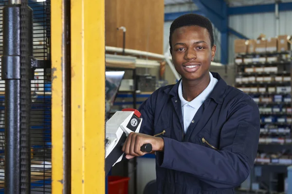 Travailleur d'usine utilisant un élévateur à fourche motorisé pour charger des marchandises — Photo