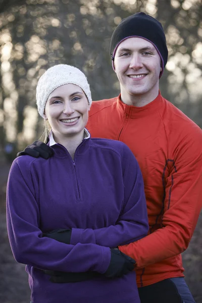 Retrato de casal no inverno correr através da floresta — Fotografia de Stock