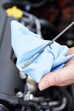 Dipstick 'teki motor yağı seviyesini kontrol eden adamın yakın çekimi