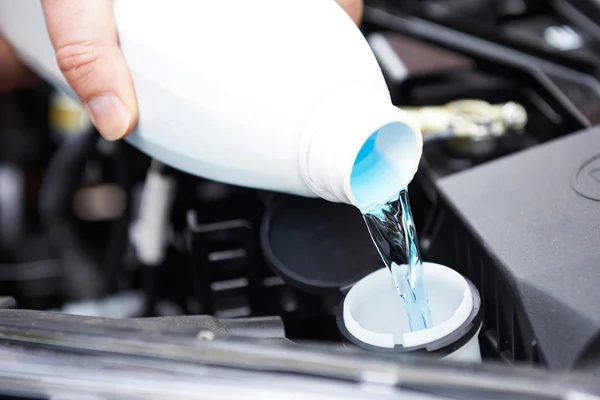 Gros plan de l'homme qui dépose le liquide lave-glace dans la voiture — Photo