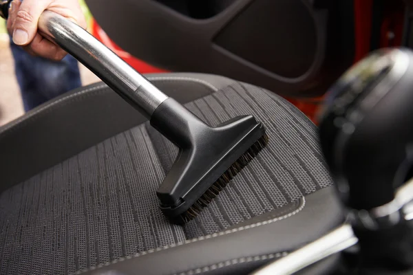 Man Hoovering zetel van de auto tijdens het reinigen van de auto — Stockfoto