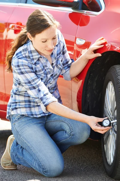 자동차 타이어 압력 계기를 사용 하 여 확인 하는 여자 — 스톡 사진