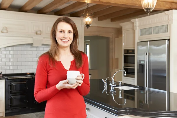 Yeni lüks donanımlı mutfakta ayakta Olgun kadın — Stok fotoğraf