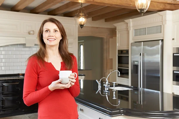 Yeni lüks donanımlı mutfakta ayakta Olgun kadın — Stok fotoğraf