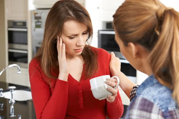 Sorgliga kvinna som tröstade hemma av kvinnliga vän — Stockfoto