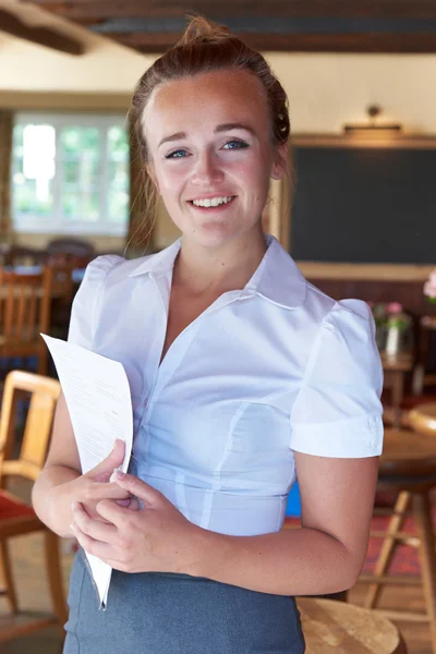 Retrato de camarera sosteniendo menú en el restaurante —  Fotos de Stock