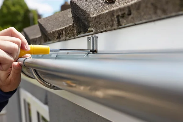 Close Up Of Man Sostituzione grondaie sulla parte esterna della casa — Foto Stock