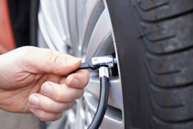 Adamın araba lastik hava basınç hattı ile şişirme yakın çekim