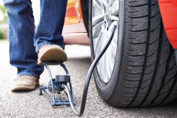 Gros plan de l'homme gonflant le pneu de voiture avec la pompe à pied — Photo