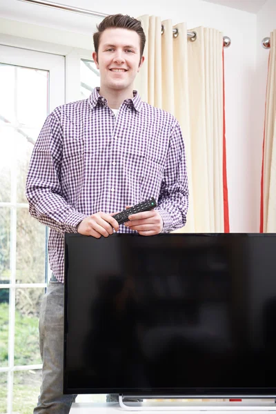 Retrato de homem orgulhoso com nova televisão em casa — Fotografia de Stock