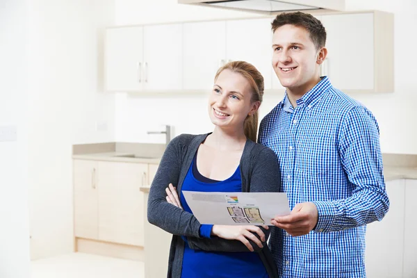 Casal feliz olhando para detalhes para a propriedade que eles esperam comprar — Fotografia de Stock