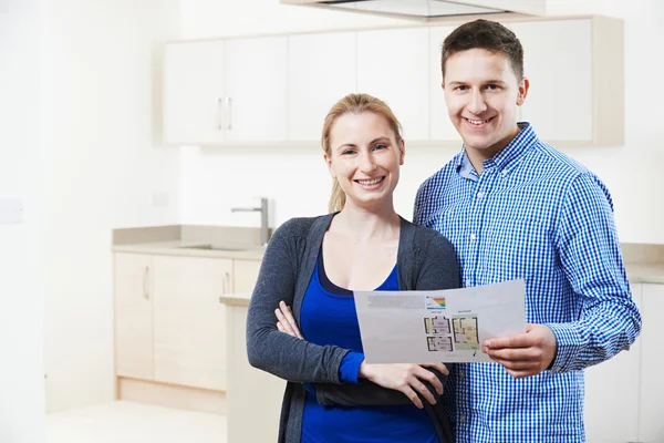 Glückliches Paar schaut sich Details für eine Immobilie an, die es zu kaufen hofft — Stockfoto