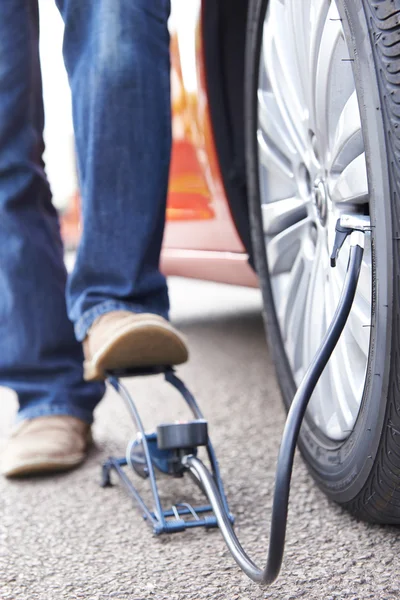 足のポンプと車のタイヤを膨らませる男のクローズ アップ — ストック写真