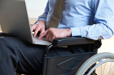 Disabled Businessman In Wheelchair Using Laptop