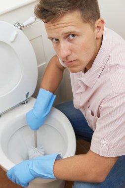 Portrait Of Unhappy Man Cleaning Toilet