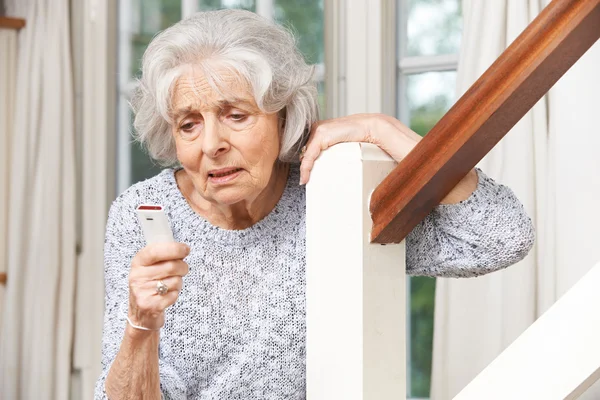 Donna anziana malata che utilizza l'allarme personale a casa — Foto Stock