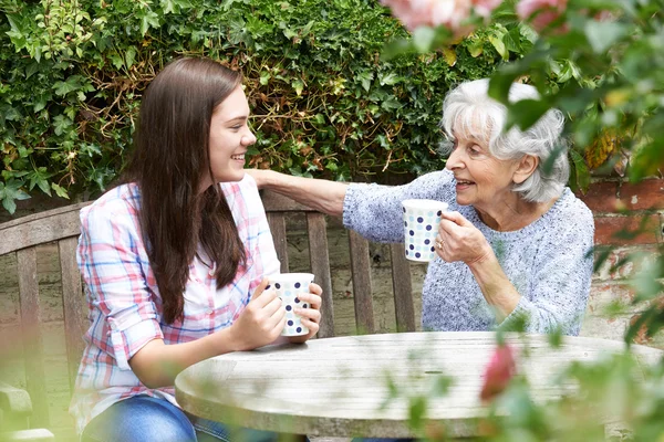 Nastoletnia wnuczka relaksujący z babcia w ogrodzie — Zdjęcie stockowe