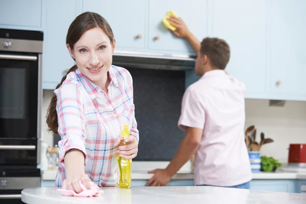 Pareja limpieza cocina superficies y armarios juntos — Foto de Stock