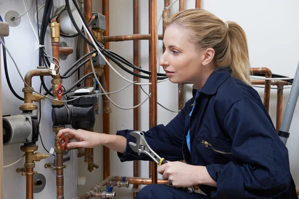 Vrouwelijke loodgieter werken aan centrale verwarming boiler — Stockfoto