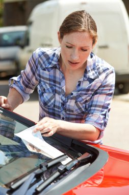 Frustrated Female Motorist Looking At Parking Ticket