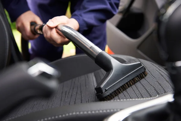 Homem Hoovering assento do carro durante a limpeza do carro — Fotografia de Stock