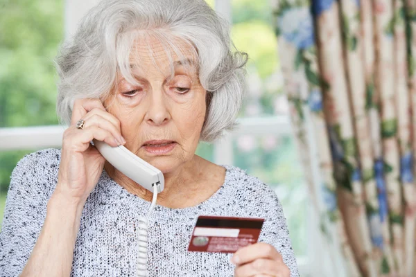 Seniorin gibt am Telefon Kreditkartendaten an — Stockfoto