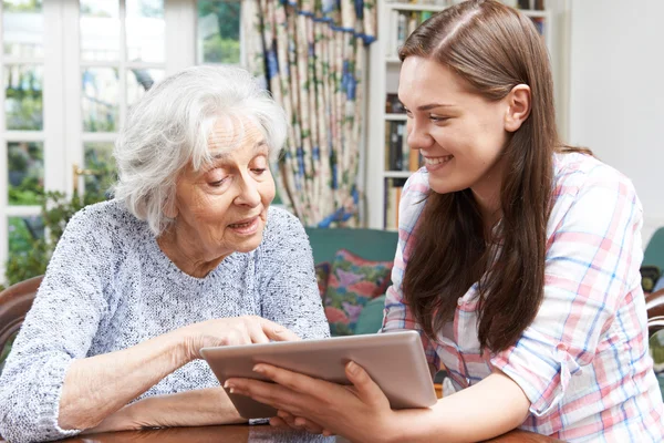 Teenage nipote mostrando nonna come utilizzare scheda digitale — Foto Stock