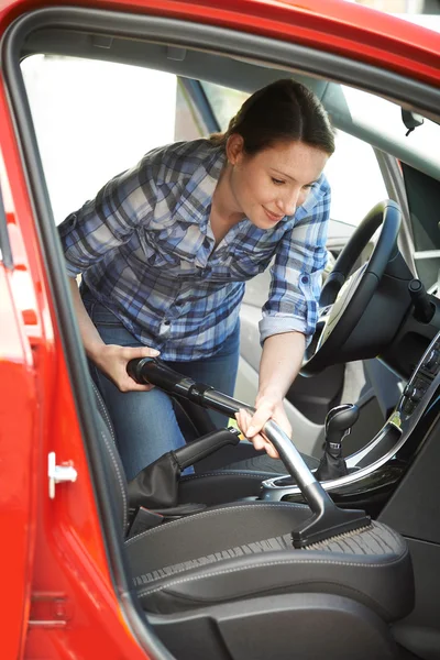 Γυναίκα τον καθαρισμό στο εσωτερικό του αυτοκινήτου χρησιμοποιώντας ηλεκτρική σκούπα — Φωτογραφία Αρχείου