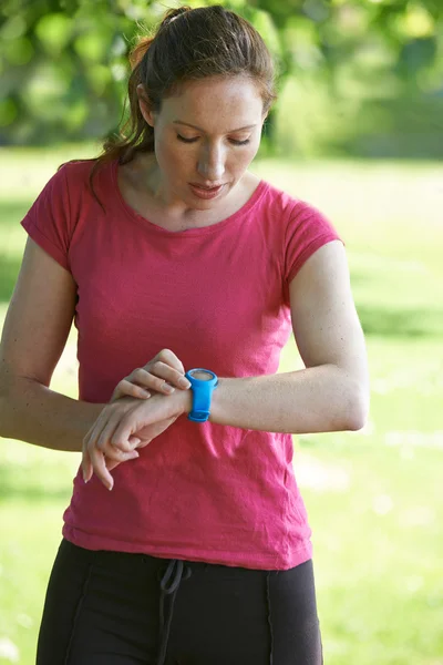 Female Runner In Park Checking Time Using Stopwatch — Stock Photo, Image