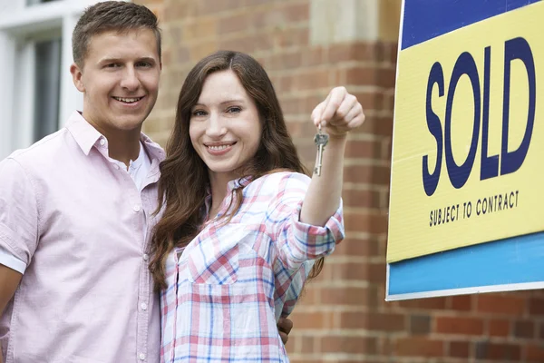 Emocionada pareja fuera de las nuevas llaves de retención del hogar —  Fotos de Stock