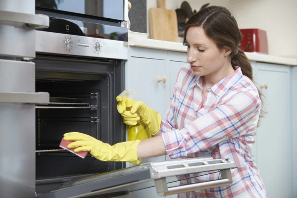 Βαρεθεί γυναίκα καθαρισμού φούρνο στο σπίτι — Φωτογραφία Αρχείου