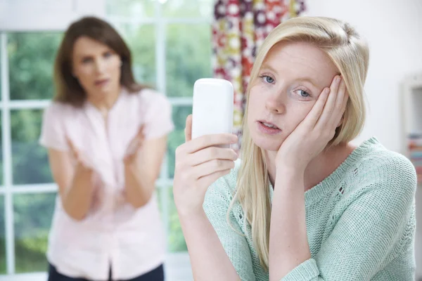 Мать спорит с дочерью-подростком из-за использования мобильного телефона — стоковое фото