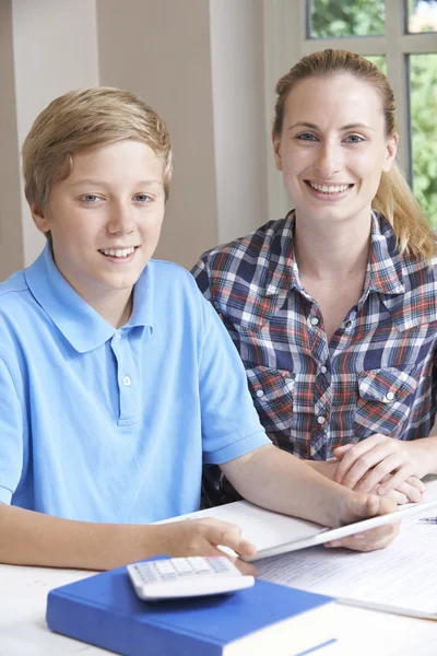 Tutora casera femenina ayudando a niño con estudios usando tableta digital — Foto de Stock