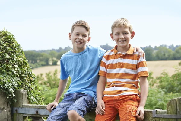 Портрет двох хлопчиків сидячи біля воріт разом — стокове фото