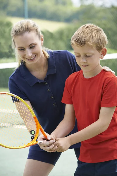 Тренер по теннису дарит урок мальчику — стоковое фото