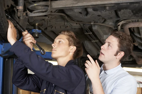 Meccanico e apprendista che lavorano insieme sull'auto — Foto Stock