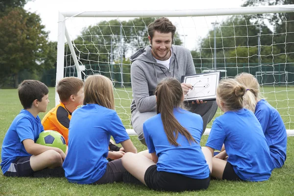 Trainer referiert vor Grundschulfußballteam — Stockfoto