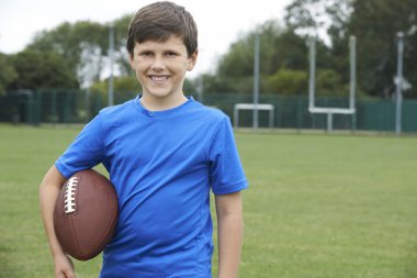 Okul futbol sahasında topu tutan çocuk portresi