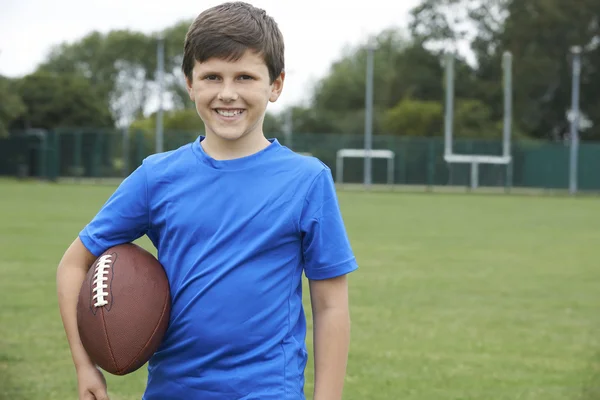 Retrato de menino segurando bola no campo de futebol da escola — Fotografia de Stock