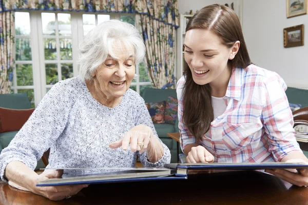 Abuela mirando álbum de fotos con nieta adolescente —  Fotos de Stock