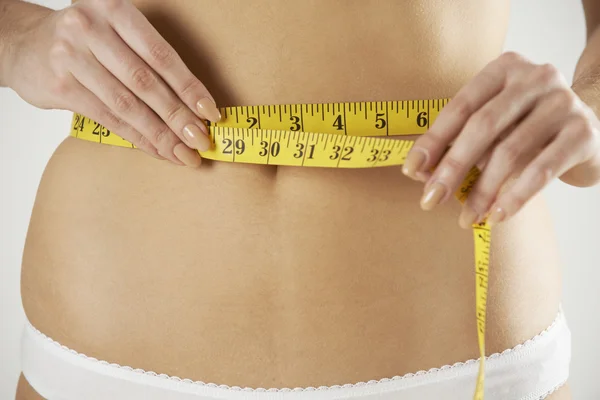 Close-Up Of Woman In Underwear Measuring Waist With Tape — Stock Photo, Image