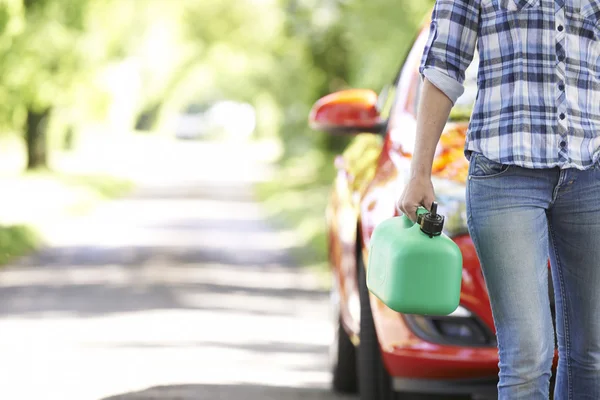 Mujer motorista que lleva combustible puede junto a coche roto — Foto de Stock