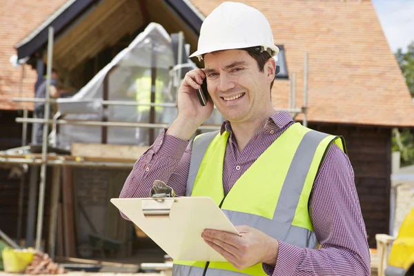 Arkitekt på byggnadsplatsen med mobiltelefon — Stockfoto